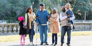 Multi-generational family in a park highlighting long-term care plan necessity