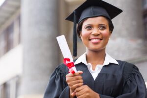 Female student in cap and gown holding a diploma